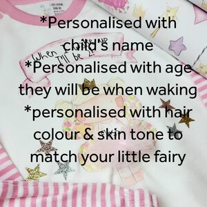 Pu&ograve; includere: Un body bianco con strisce rosa e bordino rosa. Il body presenta un disegno di una fata con una corona e un vestito rosa. Il testo sul body recita "*Personalizzato con il nome del bambino *Personalizzato con l'et&agrave; che avr&agrave; al risveglio *personalizzato con il colore dei capelli e il tono della pelle per abbinare la tua piccola fata"