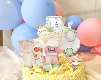 May include: A yellow cake decorated with white chocolate shavings and topped with farm animal themed cake toppers. The cake says "Today" and "2" on the tractor topper and "Emily" on the girl topper.