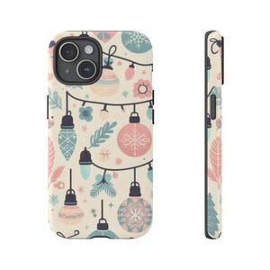 May include: A phone case with a festive design. The case features a cream background with a pattern of Christmas lights, ornaments, and floral elements in pastel pink, blue, and cream colors. The side view shows a matching design.