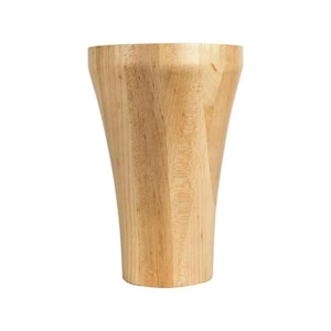 May include: A light-colored wooden furniture leg with a unique, curved design. The leg is made of solid wood and has a natural finish, showcasing the wood grain. The leg tapers from a wider top to a narrower base.