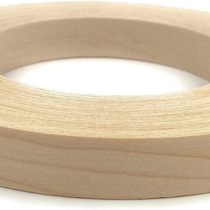 May include: A roll of natural wood veneer edge banding. The banding is light brown and has a wood grain pattern. It is rolled up and ready to be used for edging furniture or other projects.