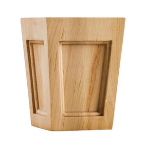 May include: A light-colored wooden decorative box with a trapezoidal shape. The box features recessed rectangular panels on the front and sides, adding a touch of detail to the design. The wood grain is visible, enhancing the natural aesthetic.