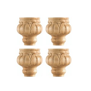 May include: Set of four wooden furniture legs with a carved floral design. The legs are unfinished and have a natural wood color.
