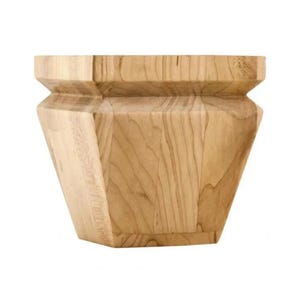 May include: A light-colored, unfinished wooden furniture leg with a geometric design. The leg has a square top, a tapered body, and a square base. The wood grain is visible throughout the piece.
