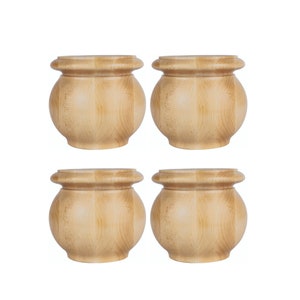May include: Set of four wooden furniture legs with a rounded, turned design. The legs are a light brown color and have a smooth finish.