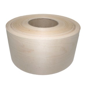 May include: A roll of natural wood veneer, a thin sheet of wood used for decorative purposes. The veneer is rolled up and has a light brown color.
