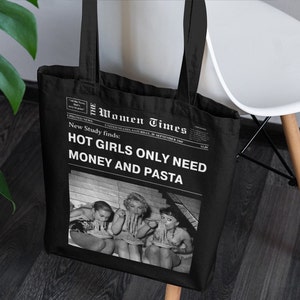Peut inclure: Sac fourre-tout noir avec un motif d'impression de journal. Le titre principal est "The Women Times" et le sous-titre est "Nouvelle étude révèle : HOT GIRLS ONLY NEED MONEY AND PASTA". L'image montre trois femmes dans une photo en noir et blanc.