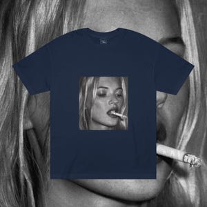 Puede incluir: Una camiseta azul marino con una foto en blanco y negro de una mujer fumando un cigarrillo. La mujer tiene el pelo rubio y lleva una camisa blanca.