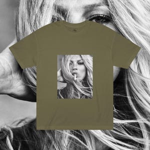 May include: A green t-shirt with a black and white photo of a woman with long hair smoking a cigarette.