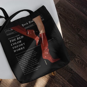 Peut inclure: Sac fourre-tout noir avec un motif rouge et blanc représentant une paire de bottes rouges et le texte "STUDIES SHOW: THE RED COLOR THEORY WORKS".