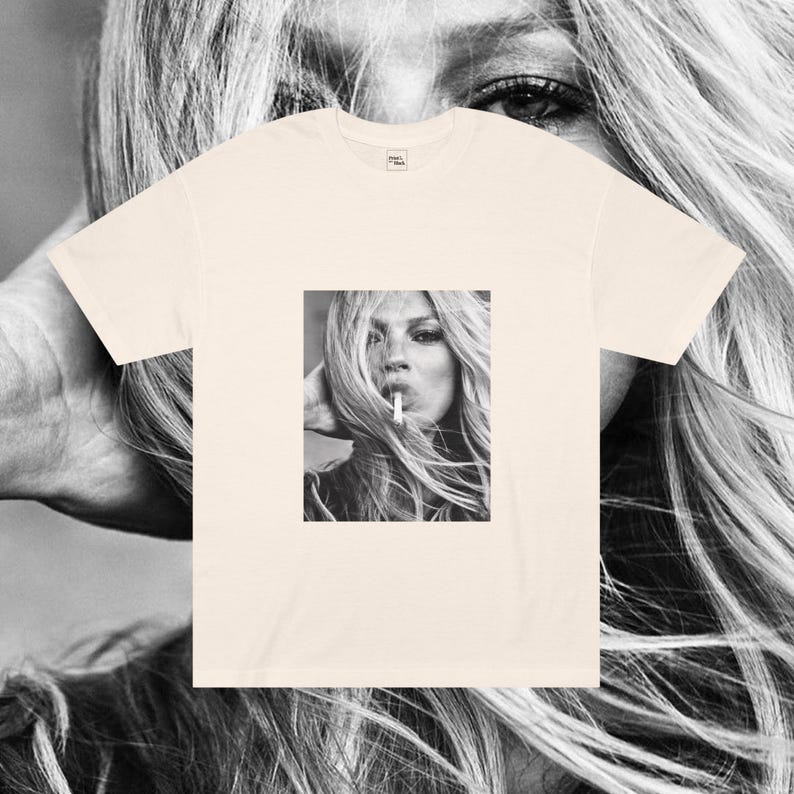 May include: A cream-colored t-shirt with a black and white photo of a woman with long hair smoking a cigarette.