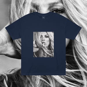 May include: A navy blue t-shirt with a black and white photo of a woman with long hair smoking a cigarette.