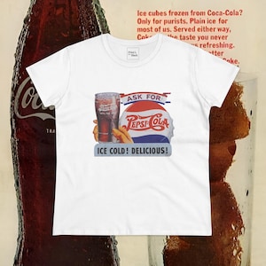 Puede incluir: Camiseta blanca con un anuncio vintage de Pepsi-Cola que muestra un vaso de Pepsi y el texto "Ask for Pepsi-Cola Ice Cold! Delicious!"