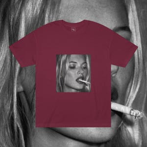 Puede incluir: Una camiseta color burdeos con una foto en blanco y negro de una mujer fumando un cigarrillo. La foto est&aacute; centrada en la camiseta.