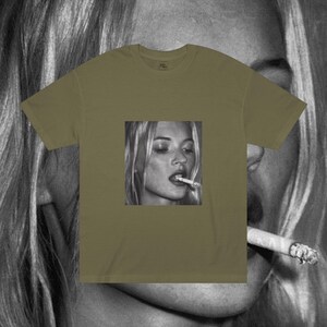 Puede incluir: Una camiseta verde con una foto en blanco y negro de una mujer fumando un cigarrillo. La mujer tiene el pelo rubio y lleva una camisa blanca.