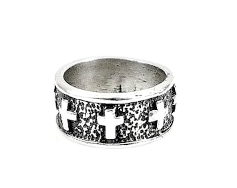 May include: A silver band ring with a textured surface and four raised cross designs.