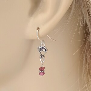 以下が含まれることがあります： ピンクの宝石ビーズが付いたシルバーのハート型ダングルイヤリング
