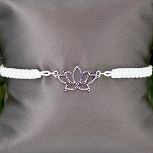 May include: White braided bracelet with a silver lotus flower charm.