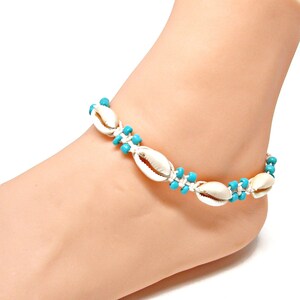以下が含まれることがあります： ターコイズビーズが付いた白い貝殻のアンクレット。アンクレットは編まれた紐で作られており、いくつかの貝殻が特徴です。