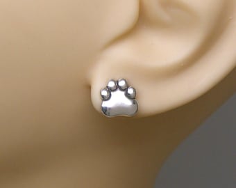 May include: A pair of silver paw print stud earrings. The earrings are small and delicate, and they would make a great gift for any dog lover.