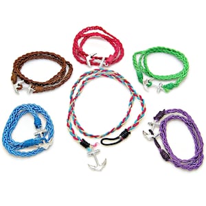 May include: A collection of nautical-themed bracelets and a necklace. The bracelets are braided in various colors, including brown, red, green, blue, and purple. Each piece features a silver-colored anchor charm. The necklace has a multi-colored braided design.