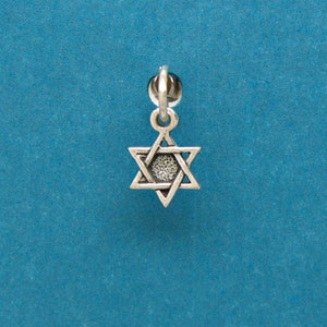 May include: A silver charm in the shape of a Star of David, a six-pointed star.