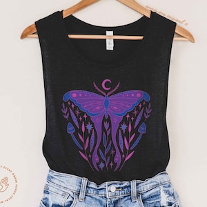 May include: Black tank top with a purple and blue butterfly graphic, surrounded by stars and flowers. The butterfly has a crescent moon on its head.
