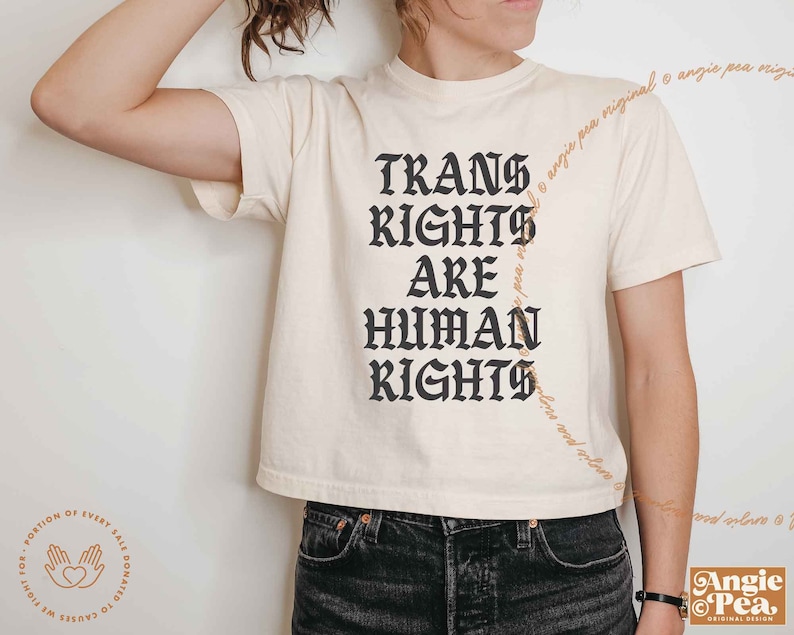 May include: A white cropped t-shirt with black text that reads "Trans Rights Are Human Rights".