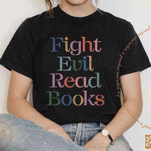 May include: Black t-shirt with the text "Fight Evil Read Books" in colorful letters. The text is stacked vertically.