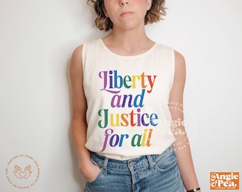May include: Cream-colored sleeveless shirt with the words "Liberty and Justice for all" in rainbow-colored text. The shirt is a casual style, suitable for everyday wear.