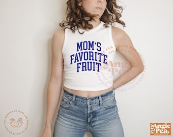 Puede incluir: Top corto blanco sin mangas con el texto azul marino "MOM'S FAVORITE FRUIT". La parte superior se combina con vaqueros azules. La imagen también incluye el logotipo de Angie Pea.