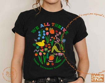 May include: Black t-shirt featuring a colourful graphic design of a garden with the text "We All Thrive Under Different Conditions".