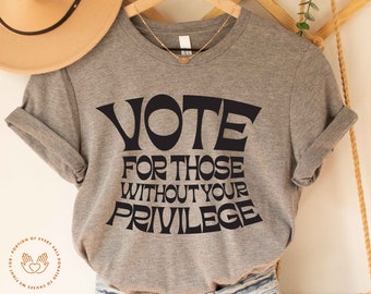 May include: Grey t-shirt with black text that reads "VOTE FOR THOSE WITHOUT YOUR PRIVILEGE".