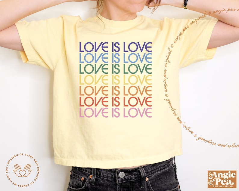 May include: A yellow cropped t-shirt with the phrase "LOVE IS LOVE" repeated in rainbow colors.