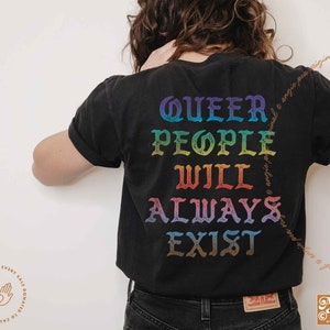May include: A black t-shirt with the text "QUEER PEOPLE WILL ALWAYS EXIST" in rainbow colors. The text is in a vintage, gothic font style.
