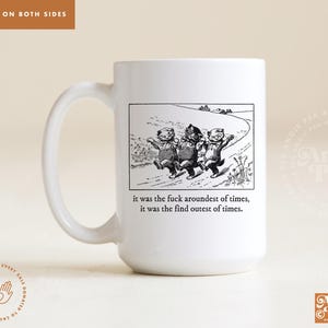 May include: White ceramic coffee mug with a black and white illustration of three cartoon cats walking on a path. The text "it was the fuck aroundest of times, it was the find outest of times." is printed below the illustration.