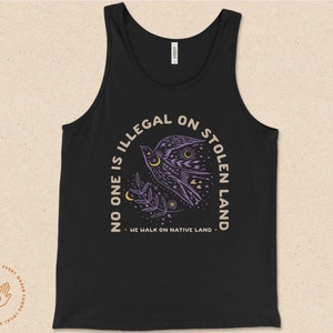 May include: Black tank top with a purple bird graphic and the text "No one is illegal on stolen land. We walk on native land."