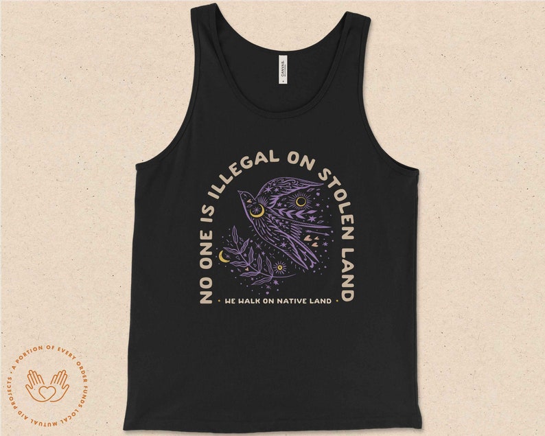 May include: Black tank top with a purple bird graphic and the text "No one is illegal on stolen land. We walk on native land."