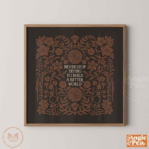 May include: Square framed art print with a dark background and floral design in shades of brown. The text "NEVER STOP TRYING TO BUILD A BETTER WORLD" is centered in white. The artwork is in a wooden frame.