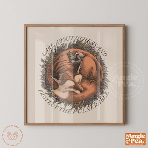 May include: A framed print featuring a curled fox and a smaller animal, surrounded by a floral wreath. The text reads "Care About Others and Protect the Vulnerable". The artwork has a vintage aesthetic.