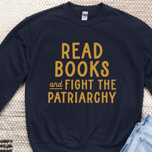 May include: A navy blue sweatshirt with the text "Read Books and Fight the Patriarchy" in yellow.