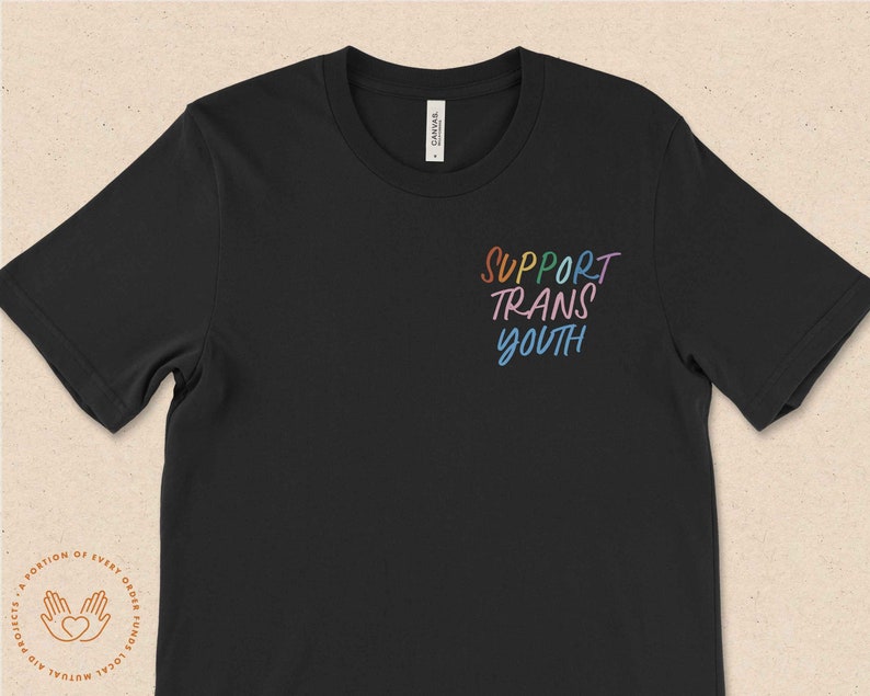 May include: Black t-shirt with the text "SUPPORT TRANS YOUTH" in rainbow colors.