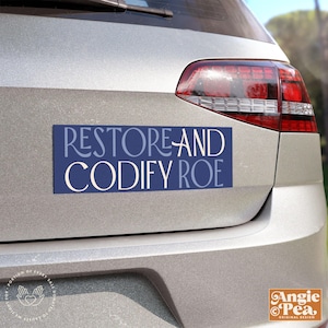 May include: A blue and white car bumper sticker with the text "RESTORE AND CODIFY ROE" in a decorative font.