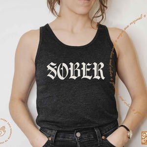 May include: A black tank top with the word "SOBER" printed in white gothic lettering.