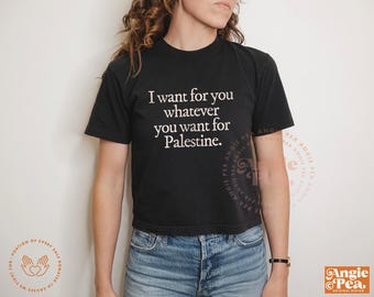May include: Black crop top with the text "I want for you whatever you want for Palestine" in white. The shirt is paired with blue denim jeans. The image also includes the Angie Pea logo.