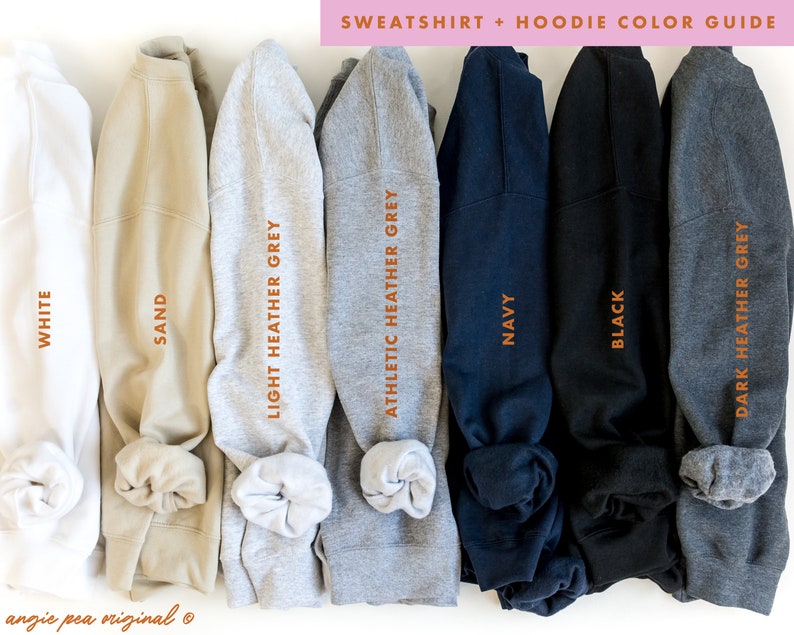 K&ouml;nnte beinhalten: Ein Farbf&uuml;hrer f&uuml;r Sweatshirts und Hoodies, der gefaltete Kleidungsst&uuml;cke in verschiedenen Farbt&ouml;nen zeigt. Das Bild zeigt wei&szlig;e, sandfarbene, hellgraue, grau melierte, marineblaue, schwarze und dunkelgraue Sweatshirts. Der Text lautet "SWEATSHIRT + HOODIE COLOR GUIDE."