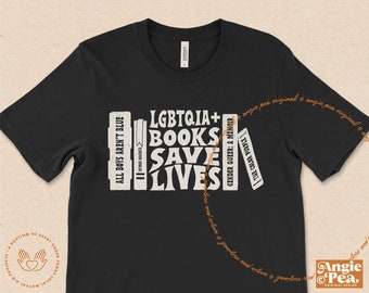 Könnte beinhalten: Schwarzes T-Shirt mit einer Grafik von Buchrücken mit dem Text "LGBTQIA+ BOOKS SAVE LIVES".