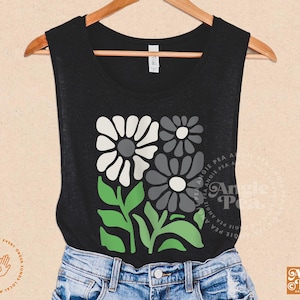 May include: Black tank top with a floral design featuring white, gray, and green flowers. The design is a stylized floral pattern with a retro feel.