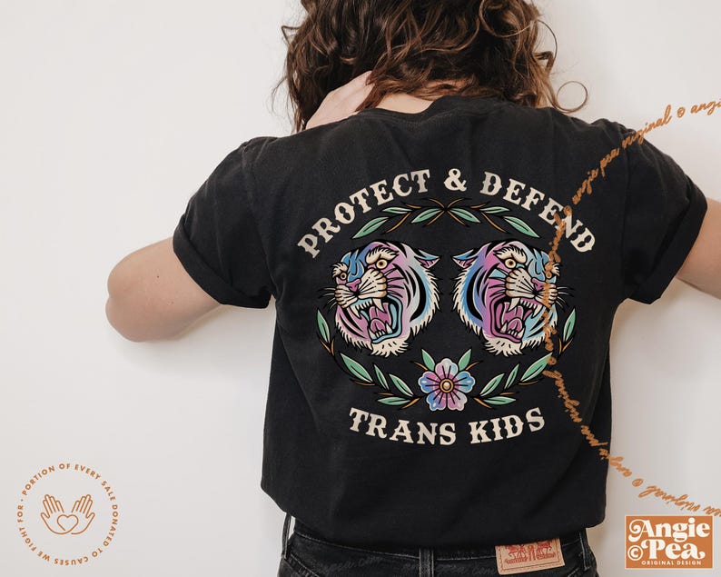 Pu&ograve; includere: Maglietta nera con una grafica di due tigri colorate con il testo "Protect & Defend Trans Kids" stampato sul retro.