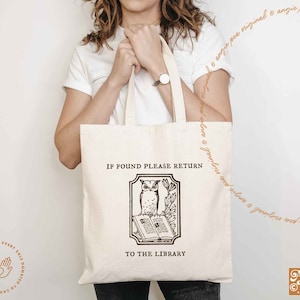 May include: A white tote bag with the text "IF FOUND PLEASE RETURN TO THE LIBRARY" printed on it. The bag features a black and white illustration of an owl perched on a book.